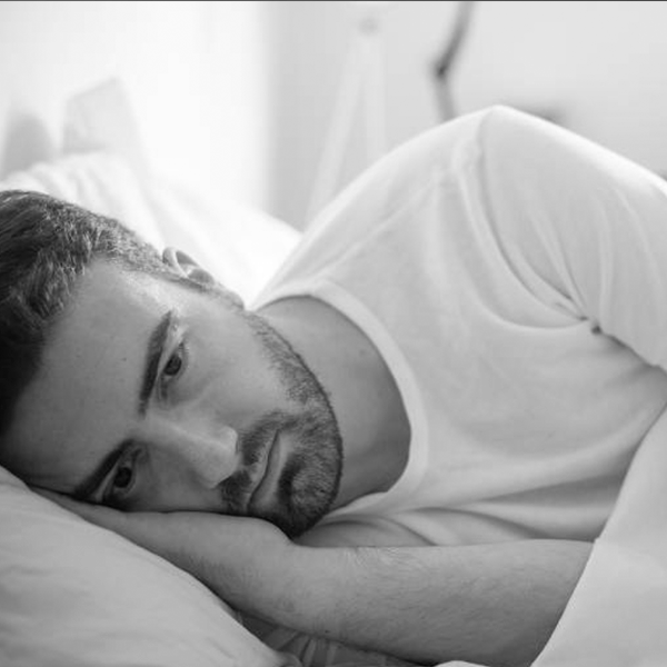 Homem deitado sozinho pensativo destaca a solidão nas festas de fim de ano